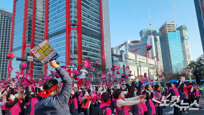 25일 오후 민주노총 서비스연맹 전국학교비정규직노동조합 조합원들이 하늘 위로 분홍색 모자를 날리고 있다. 양형욱 기자