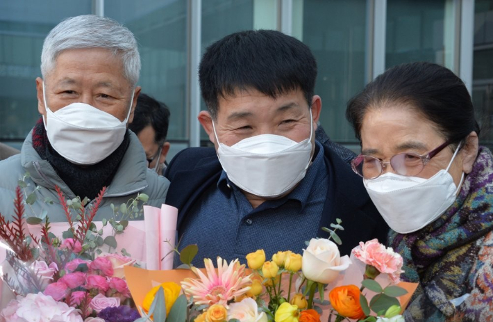 지난 2020년 12월 17일 경기도 수원시 영통구 수원지방법원에서 열린 이춘재 연쇄살인 8차 사건 재심 선고공판에서 재심 청구인 윤성여씨(가운데)가 무죄를 선고받고 법원 청사를 나와 지인들의 축하를 받고 있다. 연합뉴스