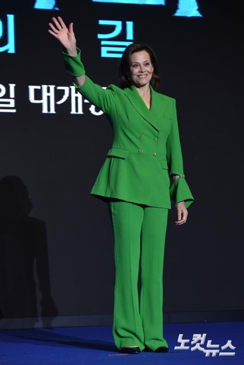 손흔들어 인사하는 시고니 위버