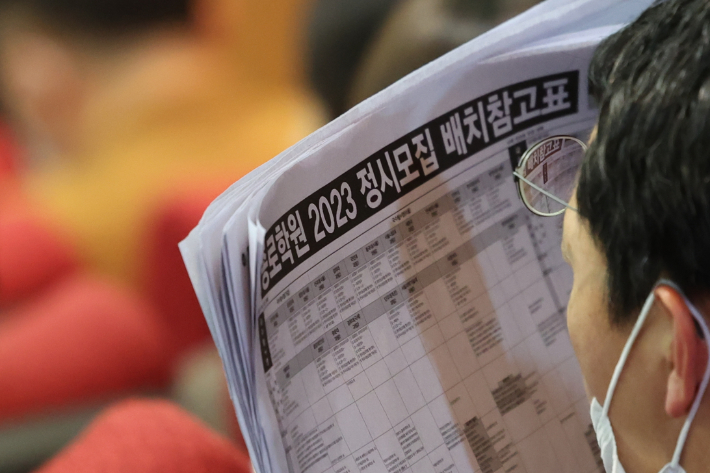 11일 오후 서울 성균관대 600주년 기념관에서 종로학원 주최로 열린 '2023 정시 합격전략 설명회'에서 수험생 학부모가 배치 참고표를 보며 입시 전문가의 설명을 듣고 있다. 연합뉴스