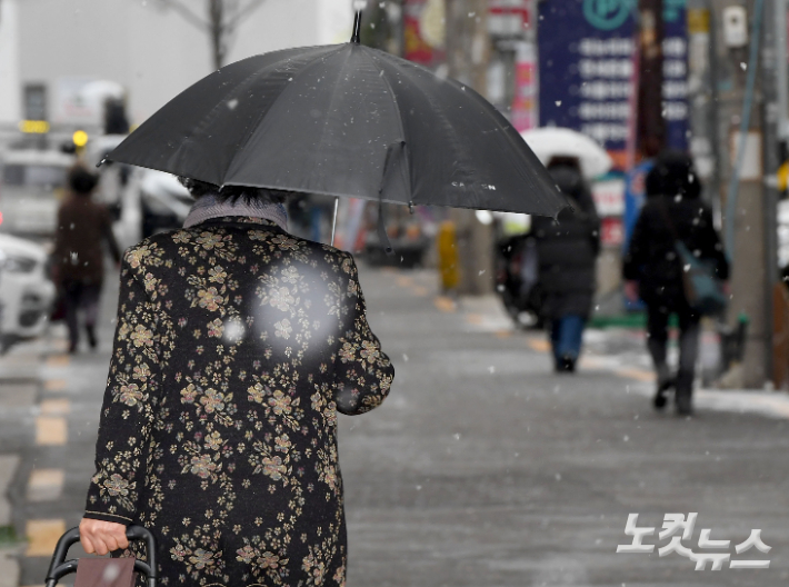 눈이 내리고 있는 지난 6일 서울시내 한 주택가에서 시민들이 발길을 재촉하고 있다. 황진환 기자