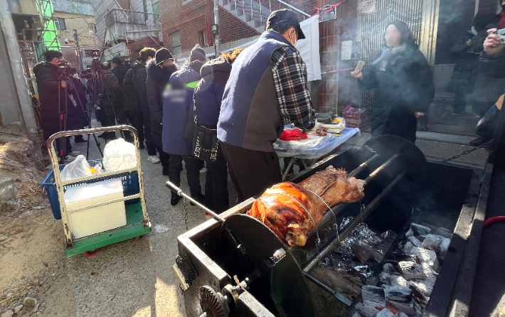 '대현동 이슬람사원 건립 반대 비대위'가 15일 대구 북구 대현동 이슬람 사원 공사장 앞에서 통돼지 바비큐를 구워 먹는 행사를 열고 있다.  연합뉴스