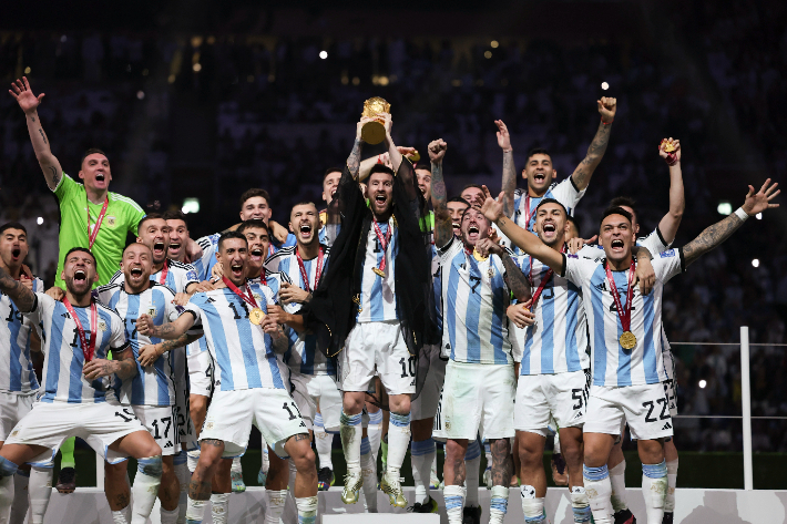 비시트를 두르고 월드컵 우승 트로피를 번쩍 들어 올리는 아르헨티나 리오넬 메시. 연합뉴스
