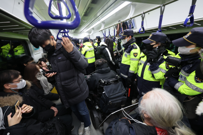 전국장애인차별철폐연대 회원들이 19일 오전 서울 지하철 1호선 용산역에서 지난 14일 지하철 탑승 시위 중 무정차 통과 조치에 규탄하며 기습시위를 하고 있다. 연합뉴스