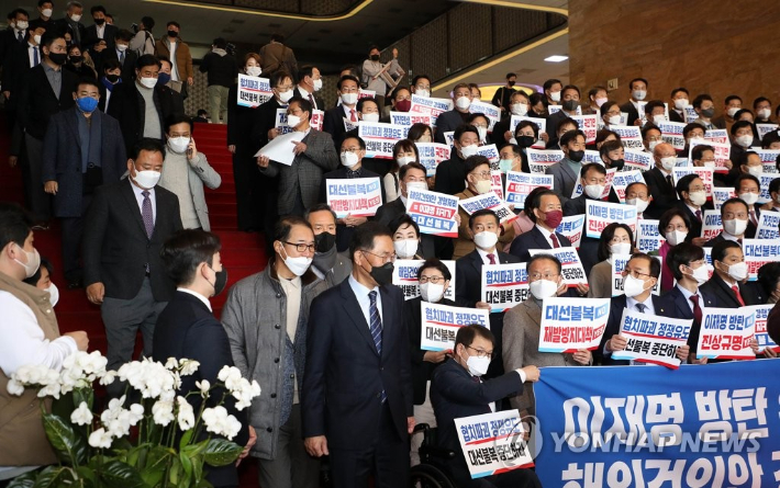 국민의힘 의원들이 11일 국회 로텐더홀 계단에서 이상민 행정안전부 장관 해임 건의안 강행 처리를 규탄하는 피켓을 들고 있는 가운데 본회의 표결을 마친 더불어민주당 의원들이 계단을 내려오고 있다. 연합뉴스