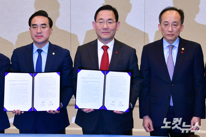 국민의힘 주호영 원내대표(가운데)와 더불어민주당 박홍근 원내대표(왼쪽)가 22일 서울 여의도 국회에서 추경호 경제부총리 겸 기획재정부 장관이 참석한 가운데 내년도 예산안 합의문을 들어보이고 있다. 윤창원 기자