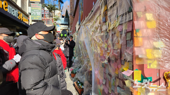 23일 핼러윈 참사 골목에 붙어있는 포스트잇을 바라보는 이태원참사유가족협의회 이종철 대표. 허지원 기자