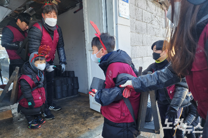 가족과 함께 연탄 배달을 하고 있는 아이들.ㅣ