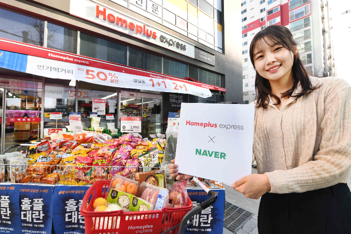 모델이 홈플러스 익스프레스 오목교점에서 홈플러스와 네이버의 온라인 사업 제휴를 알리고 있다. 홈플러스의 '1시간 즉시배송'은 지난 21일 '네이버 장보기'에 공식 입점해 네이버 이용자에게 직접 서비스를 제공하고, 다양한 프로모션을 전개 중이다. 향후 홈플러스는 네이버 등 다양한 플랫폼과 온라인사업 제휴를 점진적으로 확대한다고 밝혔다. 홈플러스 제공 