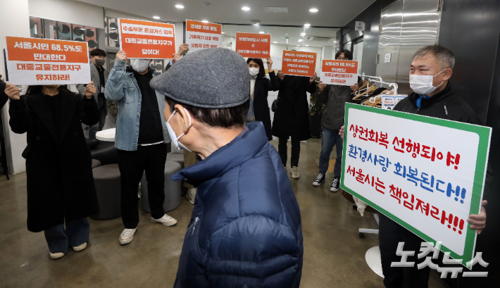 '연세로 대중교통전용지구 관련 의견수렴을 위한 시민토론회'에 참석한 상권회복 선행을 주장하는 상인과 전용지구 유지를 촉구하는 환경단체 회원들이 피켓을 들고 있다. 황진환 기자