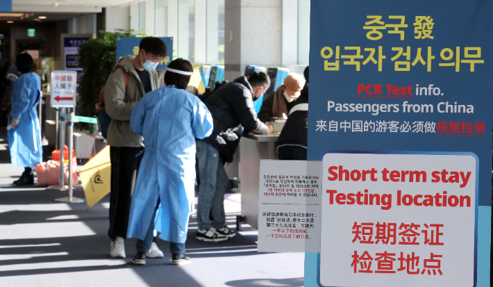 인천국제공항 제1터미널 입국장에서 방역당국 관계자들이 중국발 입국자들의 건강상태 질문지 작성여부를 확인하는 모습. 연합뉴스