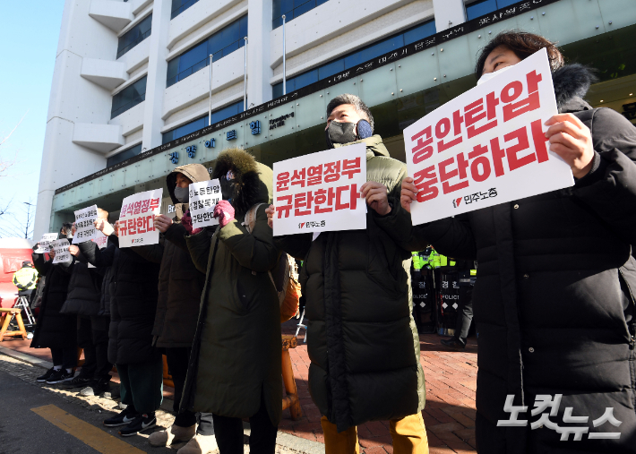 국가정보원과 경찰이 '간첩단 사건'과 관련, 민주노총에 대한 압수수색에 착수한 18일 오전 경찰들이 서울 중구 민주노총 사무실 앞에서 민주노총 관계자들이 윤석열 정부 규탄 피켓을 들고 구호를 외치고 있다. 황진환 기자