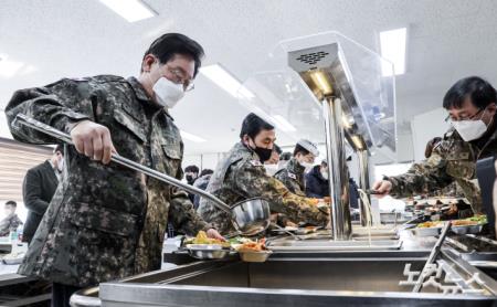 이재명 더불어민주당 대표가 19일 오후 경기도 파주 소재 방공부대를 방문해 단거리 지대공 유도미사일 천마 등을 살펴본 뒤 부대 식당에서 식판에 국을 담고 있다.