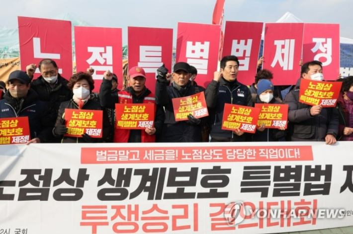 지난달 9일 서울 국회 앞에서 민주노점상전국연합 관계자들이 노점상 생계 보호 특별법 제정 투쟁 승리 결의대회를 열고 손팻말을 들고 있다. 연합뉴스