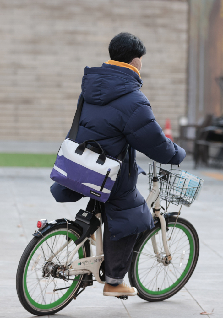 추운 날씨를 보인 지난 16일 오전 한 시민이 서울 종로구 광화문역 인근에서 목도리와 귀마개를 착용하고 자전거를 타고 있다. 연합뉴스