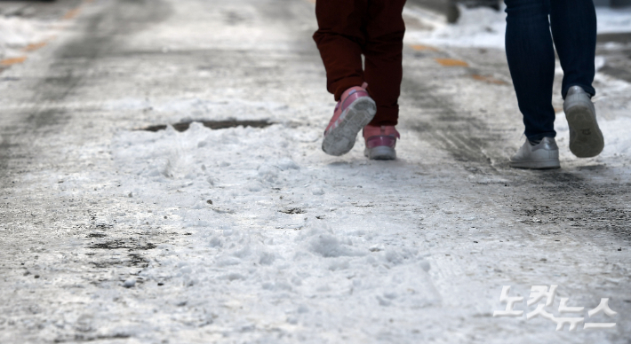 한파가 이어지고 있는 27일 오전 눈이 얼어 빙판길로 변한 서울시내 한 골목길에서 시민들이 조심스럽게 발걸음을 옮기고 있다. 기상청은 토요일인 28일에도 강추위가 이어져 아침 최저기온은 -19~-4도, 낮 최고기온은 -4~3도로 예보했다. 황진환 기자