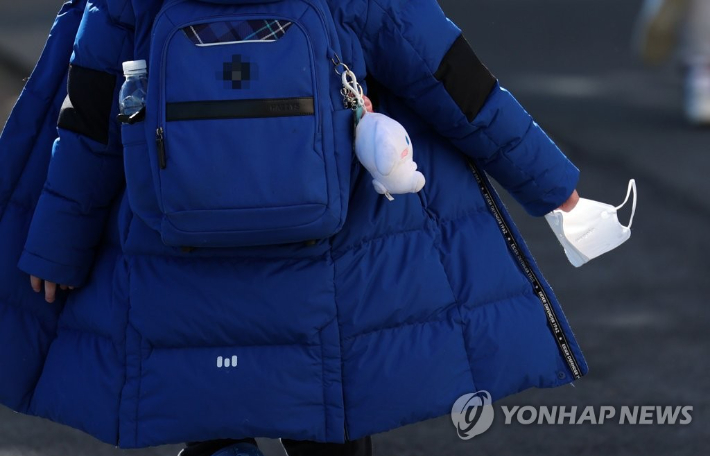 부산 남구 한 초등학교에서 한 학생이 마스크를 손에 쥐고 하교하고 있다.  연합뉴스
