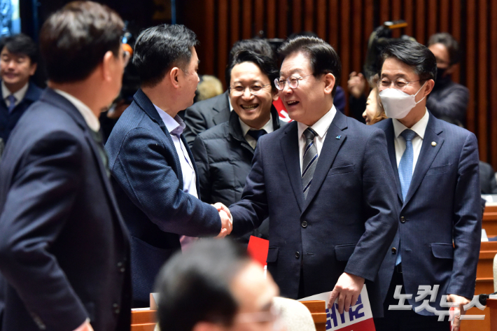 더불어민주당 이재명 대표가 30일 서울 여의도 국회에서 열린 의원총회에 참석하며 의원들과 인사를 하고 있다. 윤창원 기자