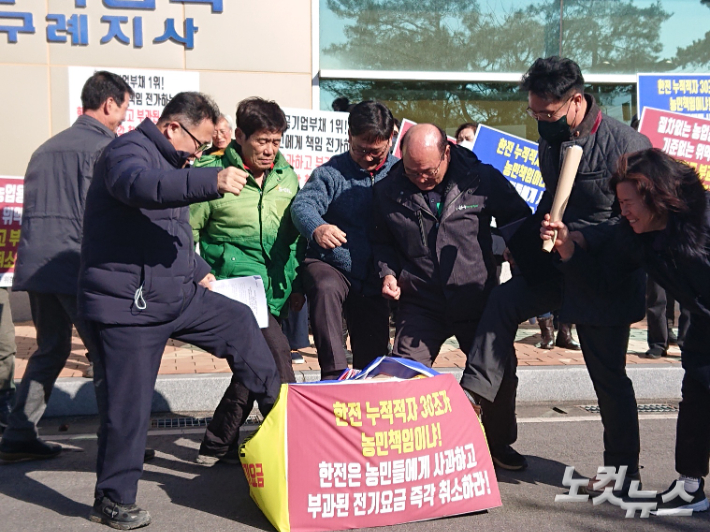 농업용전기문제 해결을 위한 구례군대책위원회는 지난 30일 오전 한전 구례지사 앞에서 기자회견을 열고 농업용 저온저장고 과징금 취소 등을 요구했다. 대책위 관계자들이 한전 로고가 그려진 상자를 밟고 있다. 유대용 기자