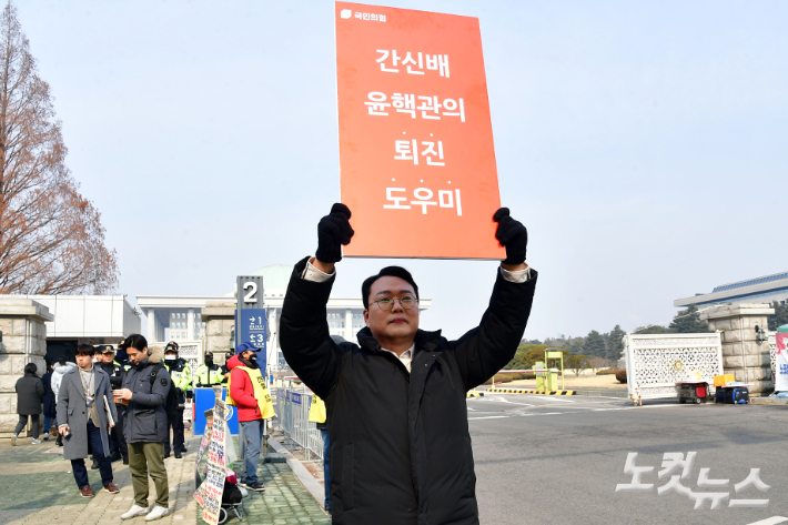 국민의힘 당대표 선거에 출마한 천하람 후보가 지난 6일 서울 여의도 국회 앞에서 '윤핵관 규탄' 피켓을 들고 1인 시위를 펼치고 있다. 윤창원 기자