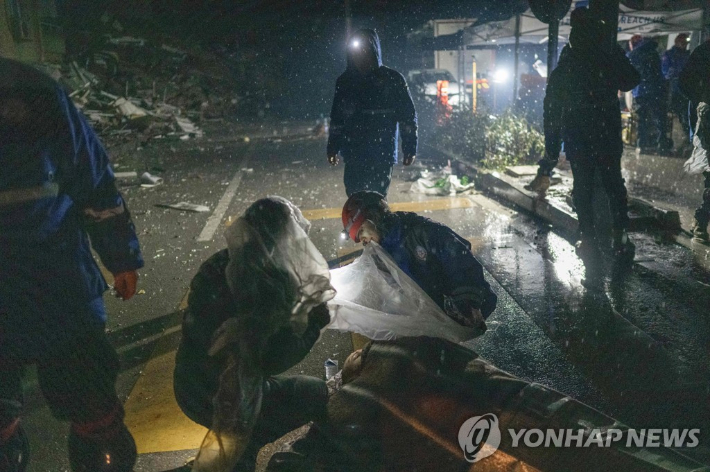 튀르키예에서 악천후 속 부상자를 돕고 있는 구조대원들. 연합뉴스