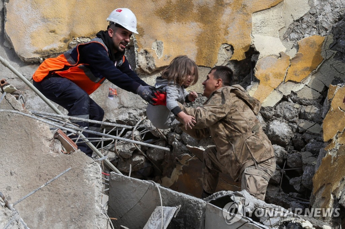 7일(현지시간) 튀르키예 하타이의 지진 피해 건물에서 구조대원들이 5살 여자 어린이를 구출하고 있다. 연합뉴스