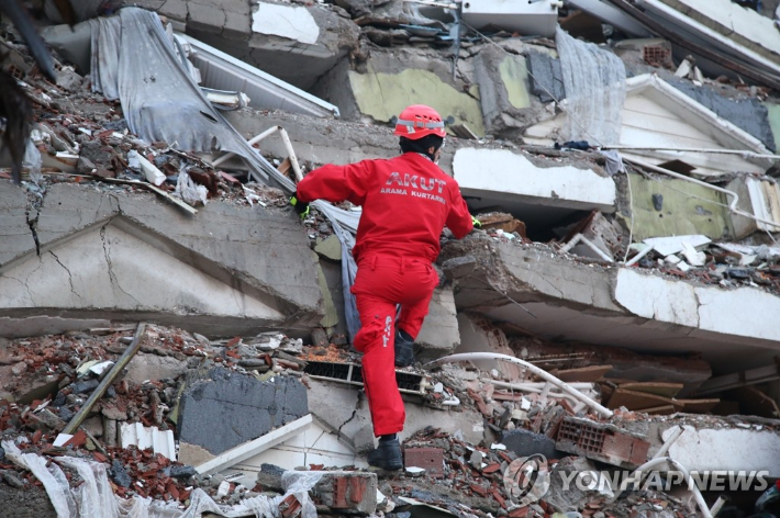 7일(현지시간) 튀르키예 카흐라만마라슈에서 한 구조대원이 강진으로 무너진 건물 잔해를 뒤지며 생존자 수색을 하고 있다. 연합뉴스