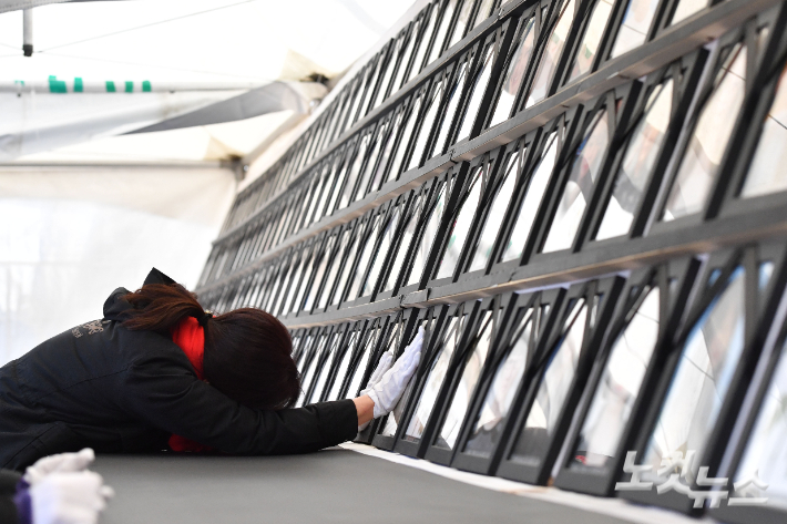 14일 오후 서울 용산구 녹사평역 광장에 마련된 이태원 참사 희생자 합동분향소에서 유가족이 영정을 만지며 슬픔에 잠겨있다. 참사 유가족 측은 이날 녹사평역 분향소를 서울광장 분향소로 이전해 통합 운영한다고 밝혔다. 류영주 기자