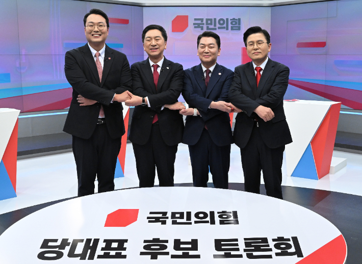 15일 서울 중구 TV조선 스튜디오에서 열린 국민의힘 당대표 후보 첫번째 TV토론에 앞서 천하람· 김기현·안철수·황교안 후보(왼쪽부터)가 손을 잡고 기념촬영을 하고 있다. 연합뉴스