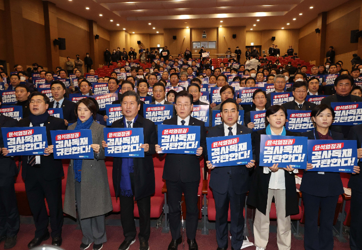 더불어민주당 이재명 대표와 당 지도부가 17일 국회 의원회관에서 열린 전국지역위원장·국회의원 긴급 연석회의에서 손 피켓을 들고 구호를 외치고 있다. 연합뉴스