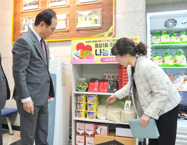 박상돈 천안시장(왼쪽)이 나눔냉장고에 마련된 생필품 등을 둘러보고 있다. 천안시 제공