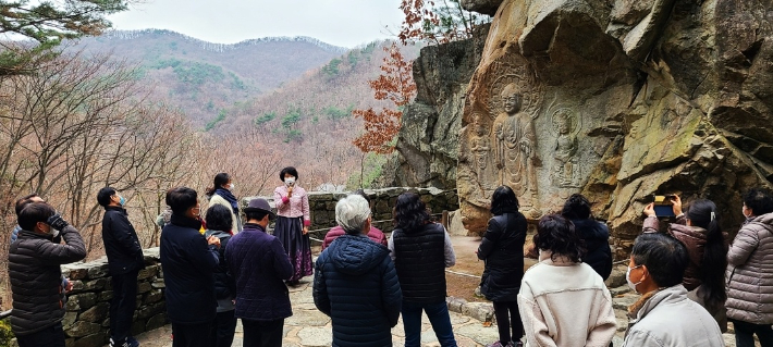 서산시 용현리마애삼존불앞에서 관광객들이 문화관광해설사의 설명을 듣고 있다. 서산시 제공