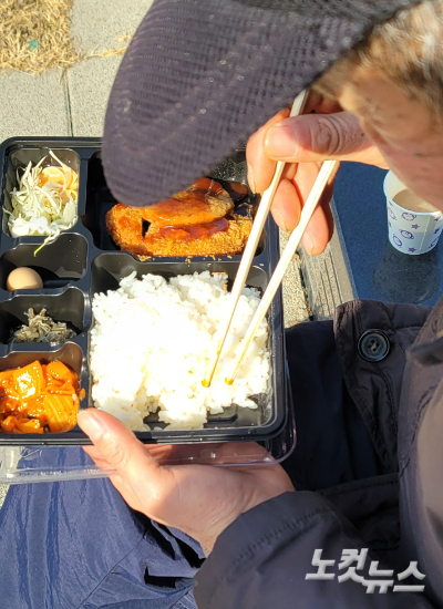노숙인 김모씨가 봉사단체에서 준 점심 도시락을 먹고 있다. 박창주 기자