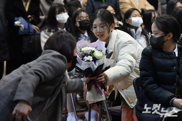 2일 오후 서울 마포구 서울여자중학교에서 열린 입학식에서 신입생이 학부모에게 꽃다발을 받고 있다. 류영주 기자