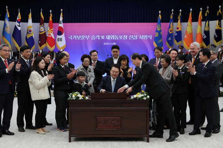 윤석열 대통령이 2일 서울 용산 대통령실 청사에서 열린 국가보훈부 승격 및 재외동포청 신설 서명식에서 관련 내용이 담긴 정부조직법 공포안에 서명한 뒤 이완규 법제처장에게 넘겨주고 있다. 대통령실 제공