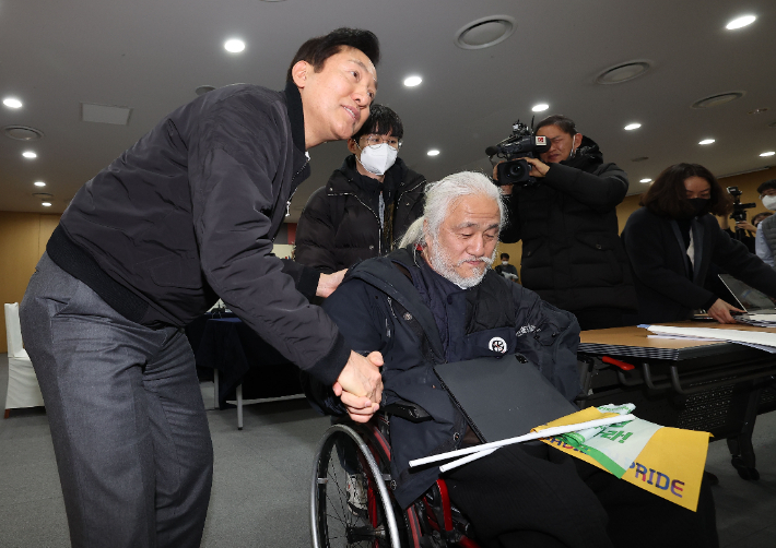 오세훈 서울시장이 지난 2월 2일 서울시청 간담회장에서 열린 전국장애인차별철폐연대와의 간담회에서 박경석 대표에게 자료를 받고 있다. 황진환 기자