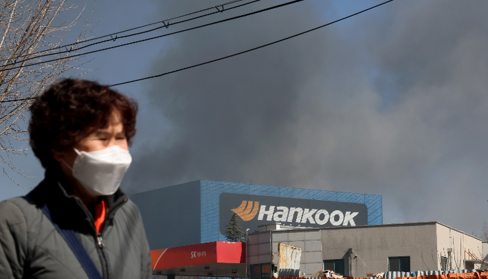 13일 오전 대전시 대덕구 목상동 한국타이어 공장에서 난 불로 인한 매캐한 연기가 인근 마을을 뒤덮자 시민들이 고통스러운 표정으로 발길을 옮기고 있다. 연합뉴스