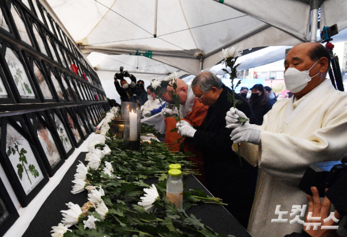 지난해 12월 서울 용산구 녹사평역 광장에 마련된 이태원 참사 시민분향소에서 7대 종단 핼러성직자들이 헌화를 하는 모습. 류영주 기자