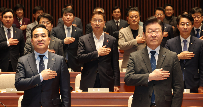 더불어민주당 이재명 대표와 의원들이 16일 오후 서울 여의도 국회에서 열린 의원총회에서 국기에 대한 경례를 하고 있다. 연합뉴스