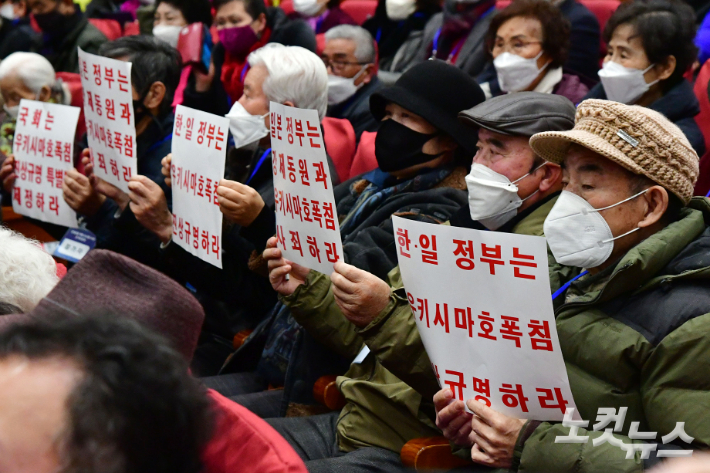 12일 서울 여의도 국회 의원회관에서 열린 강제징용 해법 논의를 위한 공개토론회에서 참석자들이 규탄 피켓을 들어보이고 있다. 윤창원 기자