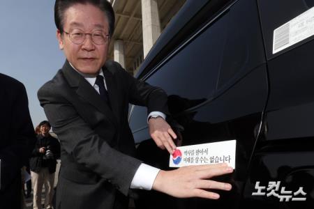 차량에 태극기 스티커 부착하는 이재명 대표