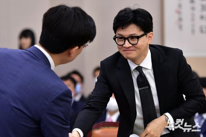 한동훈 법무부 장관이 27일 서울 여의도 국회에서 열린 법제사법위원회 전체회의에서 시대전환 조정훈 의원과 인사를 하고 있다.