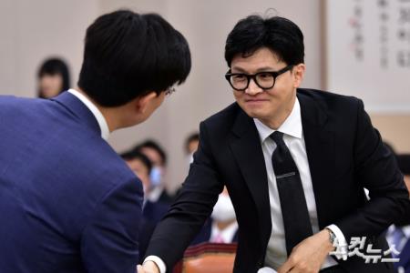 한동훈 법무부 장관이 27일 서울 여의도 국회에서 열린 법제사법위원회 전체회의에서 시대전환 조정훈 의원과 인사를 하고 있다.