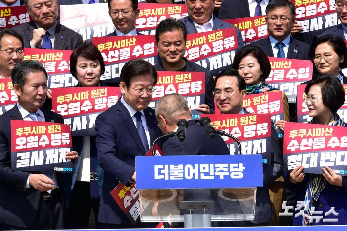 삭발한 윤재갑 의원과 악수하는 이재명 대표