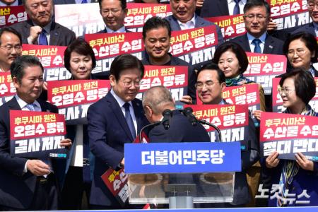 삭발한 윤재갑 의원과 악수하는 이재명 대표