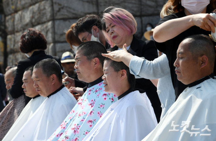 3일 오후 국회 본청 앞 계단에서 열린 '쌀값 정상화법 공포 촉구 결의대회' 참석자들이 삭발을 하고 있다. 황진환 기자