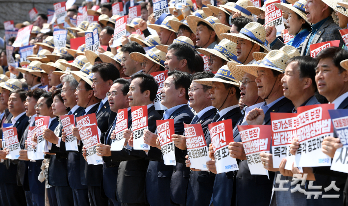 3일 오후 국회 본청 앞 계단에서 열린 '쌀값 정상화법 공포 촉구 결의대회' 참석자들이 삭발을 하고 있다. 황진환 기자