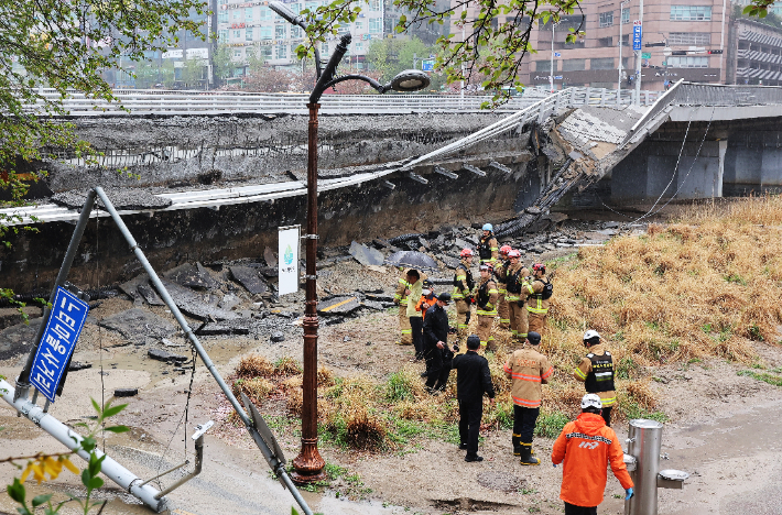 5일 오전 교량 양쪽에 설치된 보행로 중 한쪽 보행로가 갑자기 무너져 내리며 1명이 숨지고 1명이 다치는 사고가 발생한 경기도 성남시 정자교에서 소방 등 관계자들이 분주하게 움직이고 있다. 연합뉴스