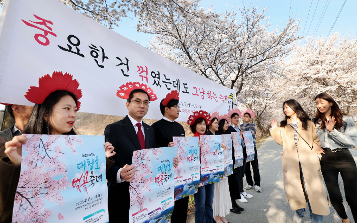 대전 동구 공무원들이 지난 달 30일 대청호 인근에서 '벚꽃이 꺾여도 축제는 개최된다'고 홍보하고 있다. 대전 동구청 제공