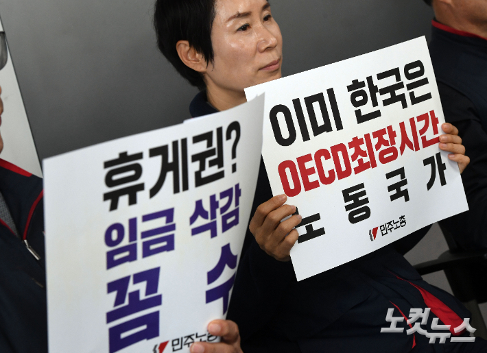 20일 오전 서울 중구 민주노총에서 열린 '윤석열 정부 노동시간 개악 안 폐기투쟁 발표' 민주노총 중앙집행위원회 기자회견에 참석자들이 손피켓을 들고 있다. 황진환 기자